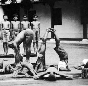 Kristhnamacharya performing yoga on top of a child